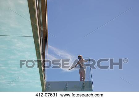 Woman with arms outstretched on modern balcony View Large Photo Image Stock Image - Woman with arms outstretched on modern balcony. Fotosearch