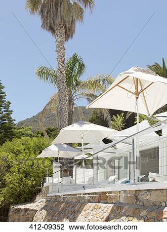 Beach umbrellas and lounge chairs on patio View Large Photo Image Stock Image - Beach umbrellas and lounge chairs on patio. Fotosearch