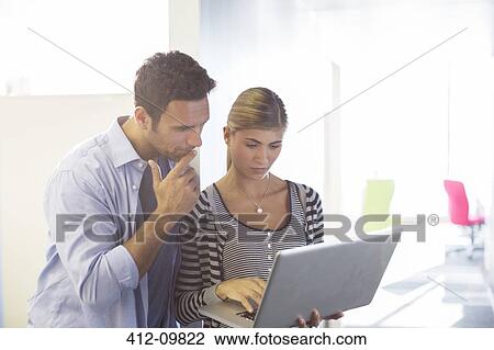 Stock Image - Business people using laptop in office. Fotosearch