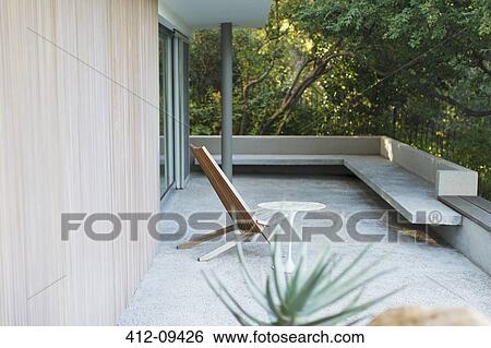 Chair and table on modern patio View Large Photo Image Stock Photograph - Chair and table on modern patio. Fotosearch