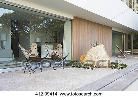 Chairs and boulder on patio of modern house View Large Photo Image Picture - Chairs and boulder on patio of modern house. Fotosearch