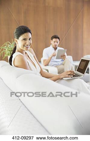 Couple relaxing in living room View Large Photo Image Stock Photo - Couple relaxing in living room. Fotosearch