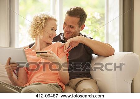 Couple shopping online on sofa View Large Photo Image Stock Photo - Couple shopping online on sofa. Fotosearch