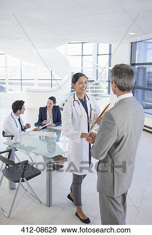Doctor and businessman shaking hands in meeting View Large Photo Image Stock Photo - Doctor and businessman shaking hands in meeting. Fotosearch