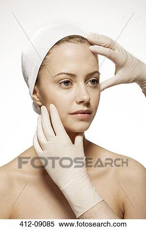 Stock Photography - Doctor examining woman's face. Fotosearch