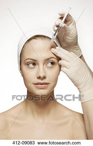 Doctor injecting botox into woman's face View Large Photo Image Stock Image - Doctor injecting botox into woman's face. Fotosearch