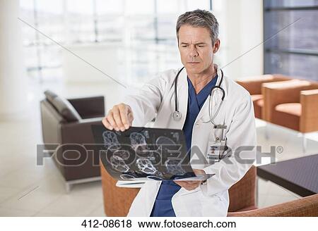 Doctor viewing head x-rays in hospital View Large Photo Image Stock Photo - Doctor viewing head x-rays in hospital. Fotosearch