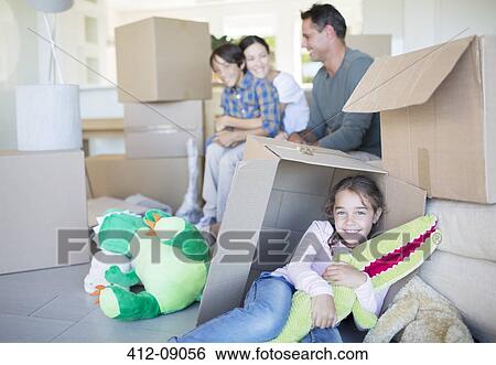 Stock Photograph - Family among cardboard boxes in livingroom. Fotosearch