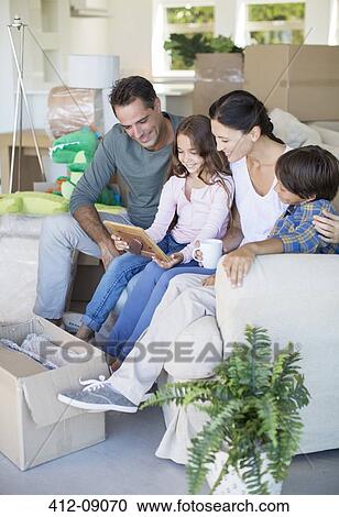 Family looking at picture frame on sofa among cardboard boxes View Large Photo Image Stock Image - Family looking at picture frame on sofa among cardboard boxes. Fotosearch