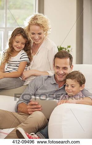 Family using digital tablet on sofa View Large Photo Image Stock Photograph - Family using digital tablet on sofa. Fotosearch