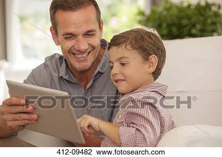 Father and son using digital tablet View Large Photo Image Stock Image - Father and son using digital tablet. Fotosearch