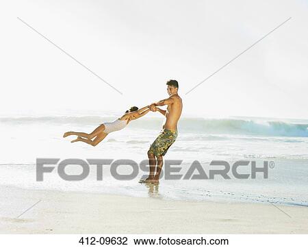 Father swinging daughter on beach View Large Photo Image Stock Image - Father swinging daughter on beach. Fotosearch
