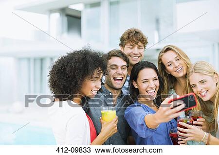 Stock Image - Friends taking self-portrait outdoors. Fotosearch