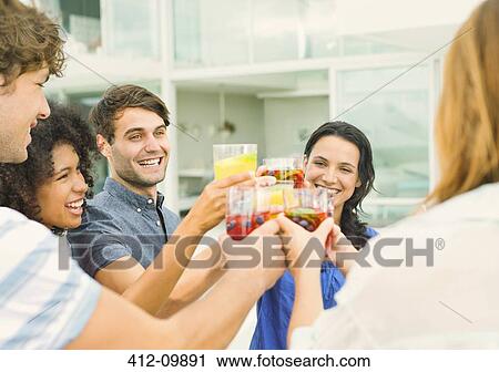 Friends toasting cocktails on patio View Large Photo Image Stock Image - Friends toasting cocktails on patio. Fotosearch