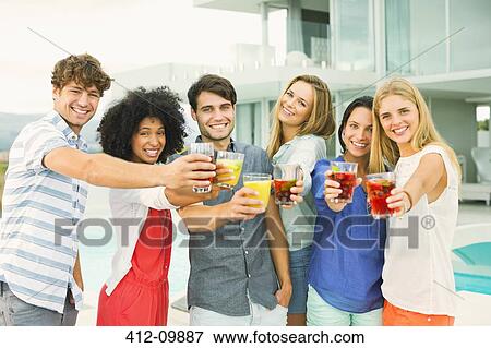 Friends toasting cocktails on patio View Large Photo Image Stock Photo - Friends toasting cocktails on patio. Fotosearch