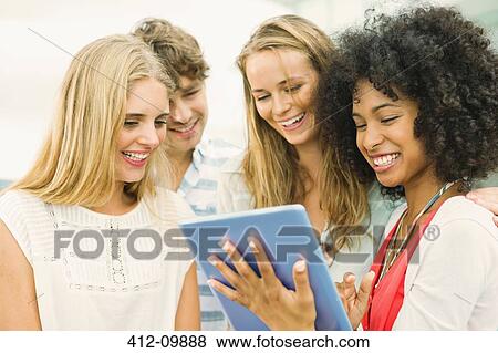 Friends using digital tablet View Large Photo Image Stock Photo - Friends using digital tablet. Fotosearch