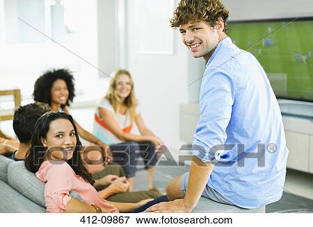 Friends watching soccer game on sofa View Large Photo Image Stock Photo - Friends watching soccer game on sofa. Fotosearch