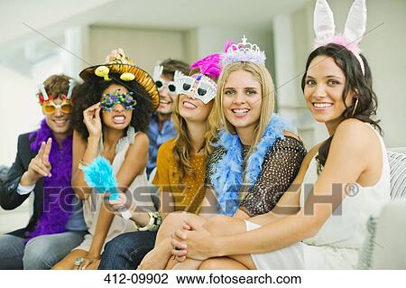 Friends wearing decorative glasses and headpieces at party View Large Photo Image Stock Image - Friends wearing decorative glasses and headpieces at party. Fotosearch