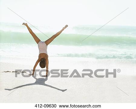 Girl doing cartwheel on beach View Large Photo Image Stock Image - Girl doing cartwheel on beach. Fotosearch