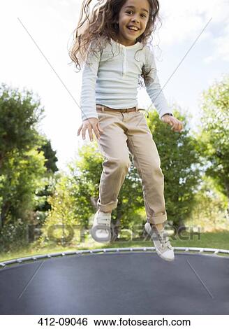 Girl jumping on trampoline outdoors View Large Photo Image Stock Photograph - Girl jumping on trampoline outdoors. Fotosearch