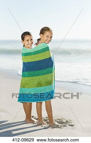 Girls wrapped in towel on beach View Large Photo Image Stock Photo - Girls wrapped in towel on beach. Fotosearch