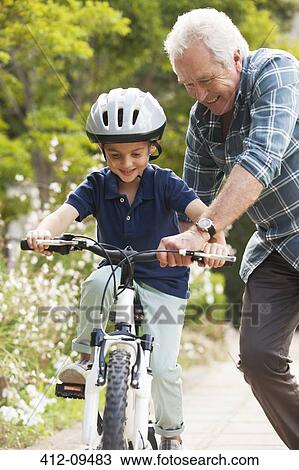 Grandfather teaching grandson to ride bicycle View Large Photo Image Stock Image - Grandfather teaching grandson to ride bicycle. Fotosearch