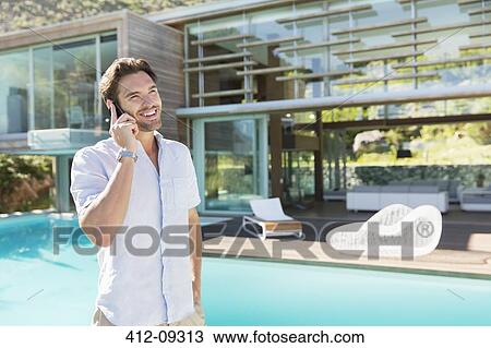 Man talking on cell phone at poolside View Large Photo Image Stock Image - Man talking on cell phone at poolside. Fotosearch