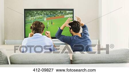 Men watching soccer game on sofa View Large Photo Image Stock Photo - Men watching soccer game on sofa. Fotosearch