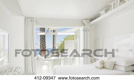 Stock Photo - Modern bedroom overlooking beach and ocean. Fotosearch