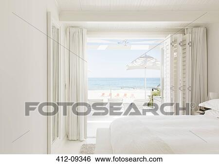 Modern bedroom overlooking beach and ocean View Large Photo Image Stock Photograph - Modern bedroom overlooking beach and ocean. Fotosearch