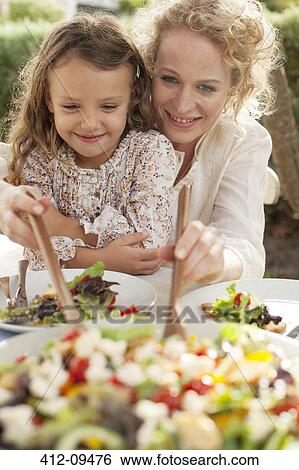 Mother and daughter eating in garden View Large Photo Image Stock Photograph - Mother and daughter eating in garden. Fotosearch