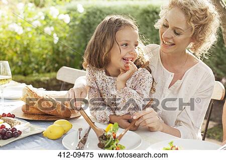 Mother and daughter eating in garden View Large Photo Image Stock Photography - Mother and daughter eating in garden. Fotosearch