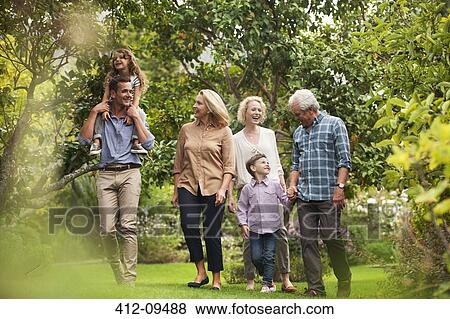 Multi-generation family walking together in park View Large Photo Image Stock Photo - Multi-generation family walking together in park. Fotosearch