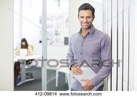 Picture - Portrait of businessman smiling in office. Fotosearch