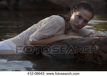 Portrait of sensual woman laying on rock in river View Large Photo Image Stock Image - Portrait of sensual woman laying on rock in river. Fotosearch