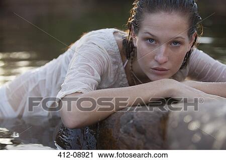 Portrait of serious woman laying on rocks in river View Large Photo Image Stock Image - Portrait of serious woman laying on rocks in river. Fotosearch