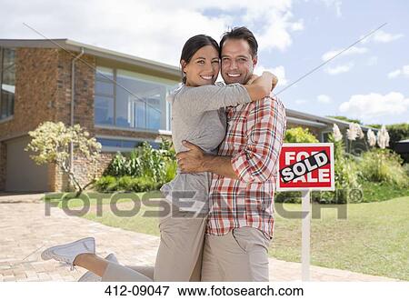 Portrait of smiling couple hugging outside new house View Large Photo Image Stock Photo - Portrait of smiling couple hugging outside new house. Fotosearch