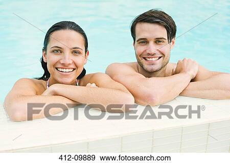 Portrait of smiling couple leaning at edge of swimming pool View Large Photo Image Stock Photo - Portrait of smiling couple leaning at edge of swimming pool. Fotosearch