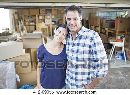 Portrait of smiling couple outside garage among cardboard boxes View Large Photo Image Stock Photography - Portrait of smiling couple outside garage among cardboard boxes. Fotosearch