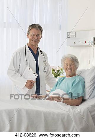 Portrait of smiling doctor and senior patient in hospital room View Large Photo Image Stock Photograph - Portrait of smiling doctor and senior patient in hospital room. Fotosearch