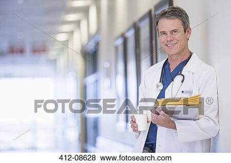 Portrait of smiling doctor in hospital corridor View Large Photo Image Stock Photo - Portrait of smiling doctor in hospital corridor. Fotosearch