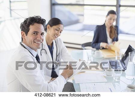 Portrait of smiling doctor in meeting View Large Photo Image Stock Image - Portrait of smiling doctor in meeting. Fotosearch