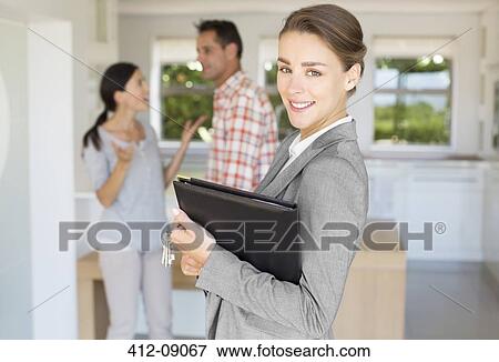 Portrait of smiling realtor with couple in background View Large Photo Image Stock Photo - Portrait of smiling realtor with couple in background. Fotosearch