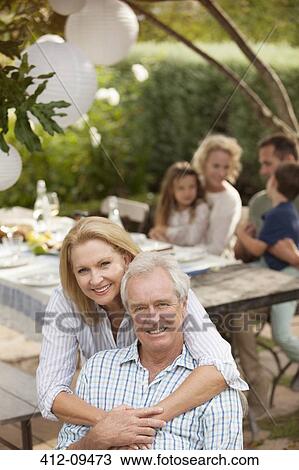 Stock Image - Portrait of smiling senior couple on patio. Fotosearch