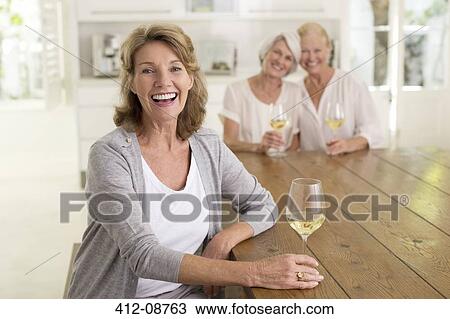 Portrait of smiling senior women drinking white wine View Large Photo Image Stock Image - Portrait of smiling senior women drinking white wine. Fotosearch