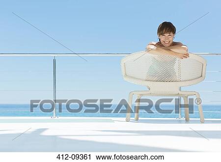 Portrait of smiling woman in chair on deck overlooking ocean View Large Photo Image Stock Image - Portrait of smiling woman in chair on deck overlooking ocean. Fotosearch