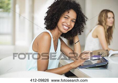Portrait of smiling woman using digital tablet at table View Large Photo Image Stock Photograph - Portrait of smiling woman using digital tablet at table. Fotosearch