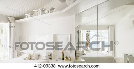 Reflection of beach and ocean in mirror of white bedroom View Large Photo Image Stock Photo - Reflection of beach and ocean in mirror of white bedroom. Fotosearch