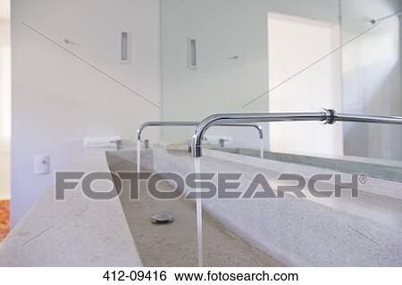 Stock Photograph - Running faucets in modern bathroom. Fotosearch