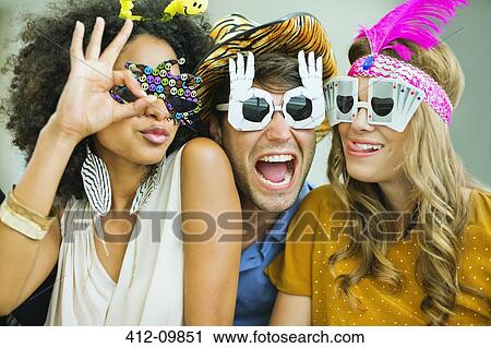 Smiling friends wearing decorative glasses View Large Photo Image Stock Image - Smiling friends wearing decorative glasses. Fotosearch